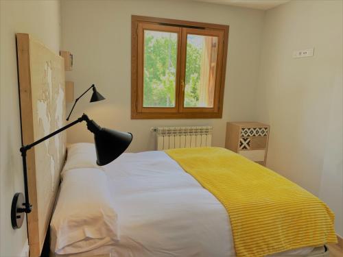 贝纳斯克Apartamento IBÓN的一间卧室配有一张带灯和窗户的床