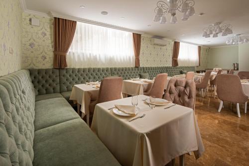 格连吉克Hotel Nizza的一间带桌椅和桌子的用餐室
