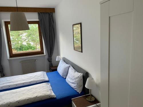 布鲁尼科希尔伯公寓式酒店的一间卧室设有蓝色的床和窗户。