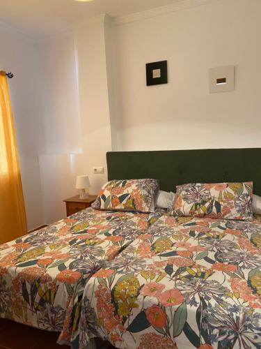 普拉多德尔雷恩托斯4号公寓酒店的一间卧室配有一张带五颜六色棉被的床