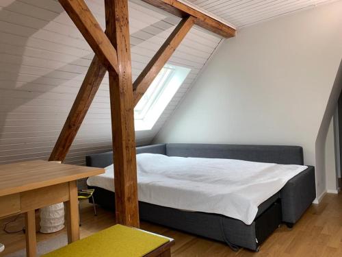 慕尼黑2-Zimmer-Apartment in München的阁楼卧室配有1张床和1张桌子