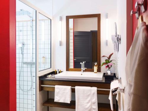 库鲁Hotel Mercure Kourou Ariatel的一间带水槽和镜子的浴室
