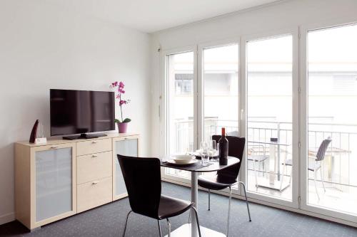 楚格希特苏格斯公寓的客厅配有桌椅和电视