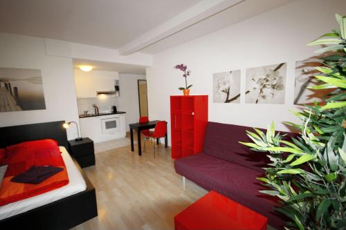 苏黎世希特斯托法彻出租公寓的客厅配有红色的沙发和桌子