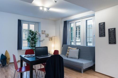 卢塞恩伊特林塔尔老城公寓的客厅配有沙发和带笔记本电脑的桌子