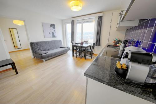苏黎世列特齐格伦HIT出租公寓的厨房以及带沙发和桌子的客厅。