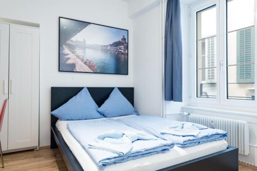 卢塞恩伊特林塔尔老城公寓的一间卧室配有一张带蓝色枕头的床