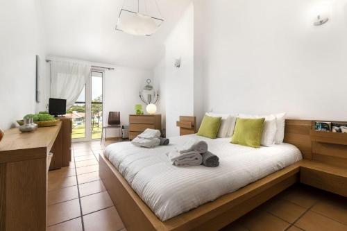 奎特里拉Vila Sol Resort 2 Bedroom Family Apartment的一间卧室配有带白色床单和绿色枕头的床。