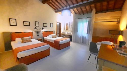圣吉米纳诺Il Palagione的一间卧室配有两张床、一张桌子和一张书桌