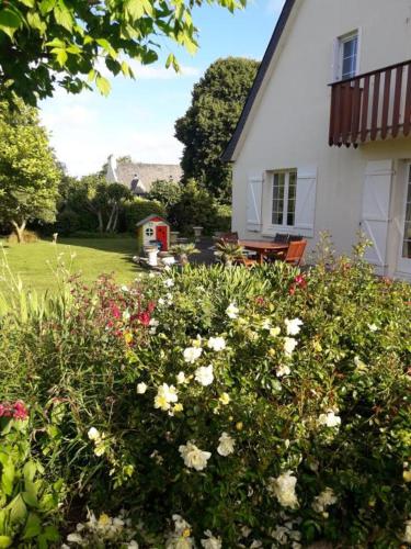 高伊斯瑙Chambre sympa belle propriété的白色的房子,花院