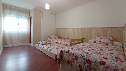 卡拉米尼亚尔镇O Lagar apartamento grande y luminoso. 8 personas.的一间卧室设有两张床和窗户。
