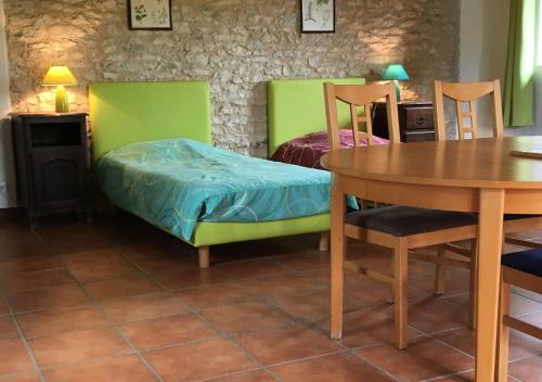 拉卡沃Le Chant du Coq的客房设有桌子、床和桌椅。