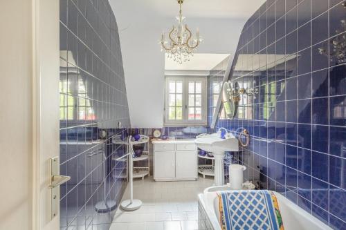 坡隆维茨普尔扎伊Ker Ys的蓝色瓷砖浴室设有浴缸和水槽