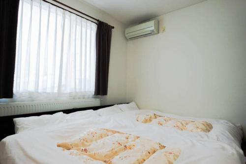 旭川STAY IN TOYOOKA的一张带两个枕头的白色床和窗户