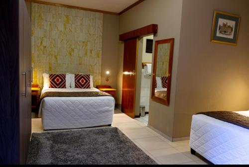 布隆方丹Bloem Spa Hotel & Conference的一间带两张床的卧室和走廊