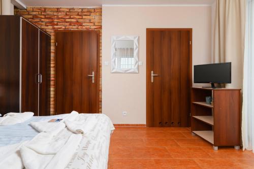 尤斯托尼莫斯基Villa Fenix的一间卧室配有一张床、一台电视和木门