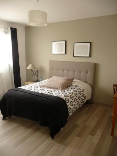 VernouilletChambres d'hôtes dans maison contemporaine的一间卧室配有一张带黑白色棉被的床