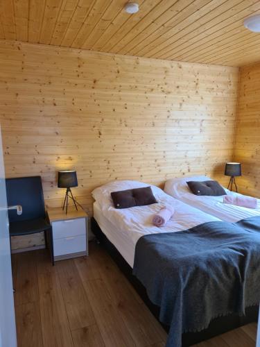 StarmýriStarmýri 2 Cottages的木墙客房的两张床