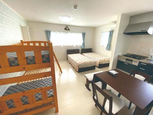 壹岐市Watatsumi no yado - Vacation STAY 44120v的带厨房的客房和一间带桌子和床的卧室