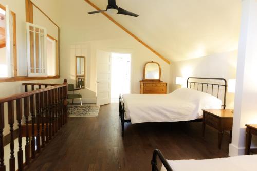MilfordJackson's Falls Country Inn的一间带两张床的卧室和楼梯