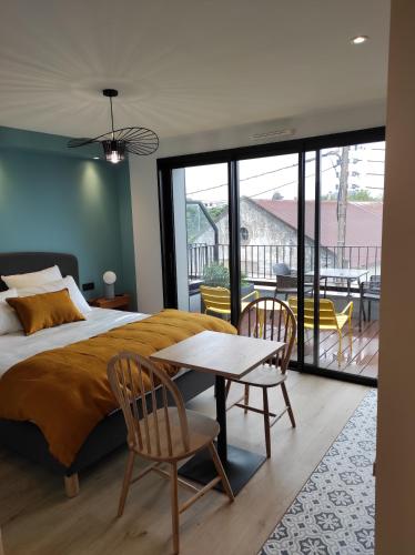 瓦讷Appart hôtel & Spa La Villa du Port的卧室配有一张床和一张桌子及椅子
