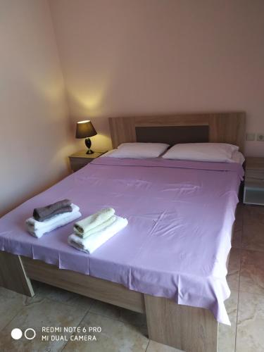 里托楚伦La betia的一间卧室配有一张紫色床和毛巾