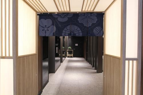 东京KOKO HOTEL Tsukiji Ginza的蓝色和白色天花板的建筑走廊