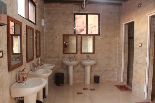 亚喀巴Bedouins life camp的浴室设有3个水槽和2面镜子