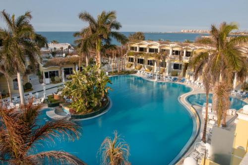 亚历山大天堂海滩度假酒店的享有棕榈树大型游泳池的顶部景致