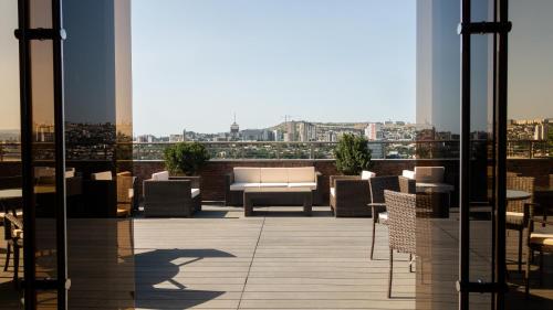 第比利斯Reed Hotel Tbilisi的大楼内带桌椅的阳台