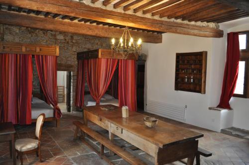 Moulès-et-Baucels布兰卡蒂庄园酒店的客厅配有桌子和红色窗帘
