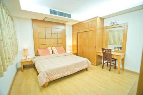 芭堤雅市中心JOLLY GUESTHOUSE & RESTAURANT的一间卧室配有一张床和一张书桌