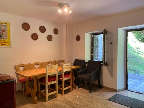 阿贝托内alla curva del Pagliai的一间带木桌和椅子的用餐室