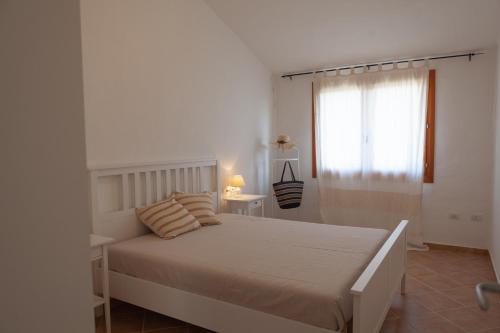 多穆斯德马里亚DomoMea - Villetta Chia的白色的卧室设有床和窗户