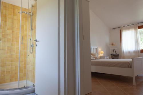 多穆斯德马里亚DomoMea - Villetta Chia的带淋浴的浴室和客房内的一张床
