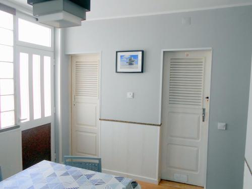 ParchalArade Rooms的一间设有两个白色门和桌子的房间