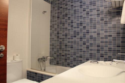 布里拉蒂卡波Hotel Ril的带淋浴、盥洗盆和卫生间的浴室
