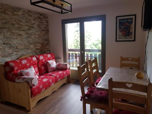 圣热尔韦莱班Appartement Saint Gervais les Bains vue imprenable Mont Blanc的客厅配有红色的沙发和桌子