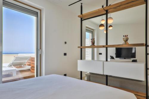 切法卢Abelia Sea Suites的卧室配有白色的床和镜子