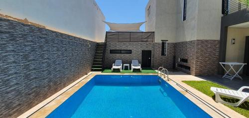 非斯Villa Nour的一座带两把椅子的游泳池以及一座建筑