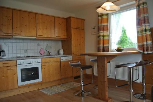 米尔施塔特Landhaus Neubauer的厨房配有木制橱柜、桌子和凳子