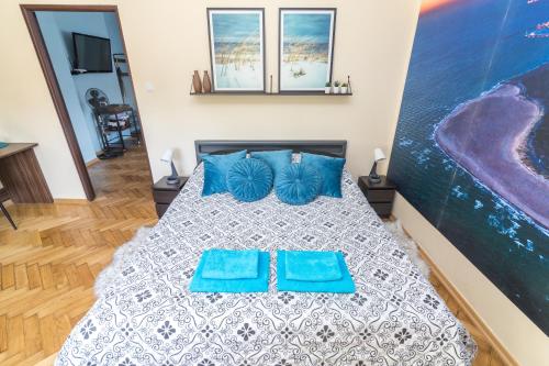 赫尔Apartament z jacuzzi的一间卧室配有一张带两个蓝色枕头的床