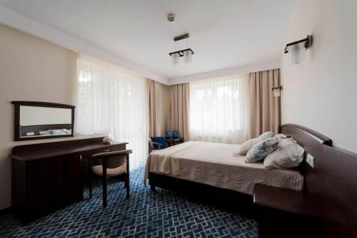 尼彻兹Villa Morskie Oko Niechorze的配有一张床和一张书桌的酒店客房