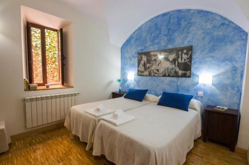 GrimaldoLa Posada de Grimaldo的一间卧室设有一张蓝色墙壁的大床