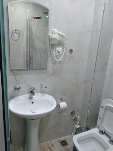 帕尔加Ηotel Della的白色的浴室设有水槽和卫生间。