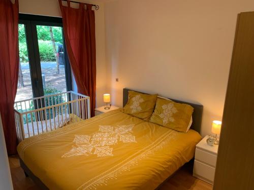 布兰肯贝赫Boothuis Ter Vaart的一间卧室配有一张带黄色床单的床和一扇窗户。