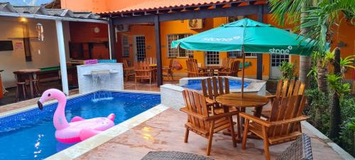 穆里基镇圣保罗旅馆的一个带桌子和粉色天鹅的游泳池