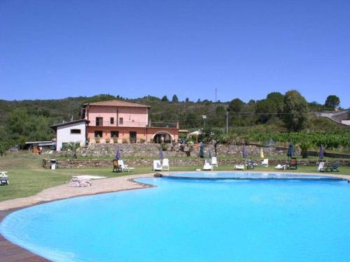 PeritoAgriturismo solare的一座大型游泳池,其建筑背景为: