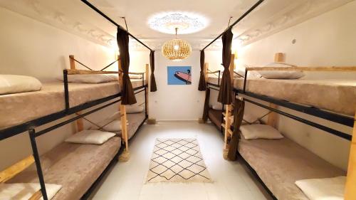 塔哈佐特Kekai Surf House的客房设有四张双层床和吊灯。