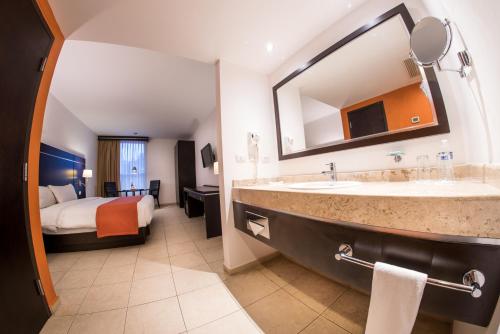 博卡德尔里奥HOTEL OLIBA Boca del Rio的酒店客房设有带床的大型浴室